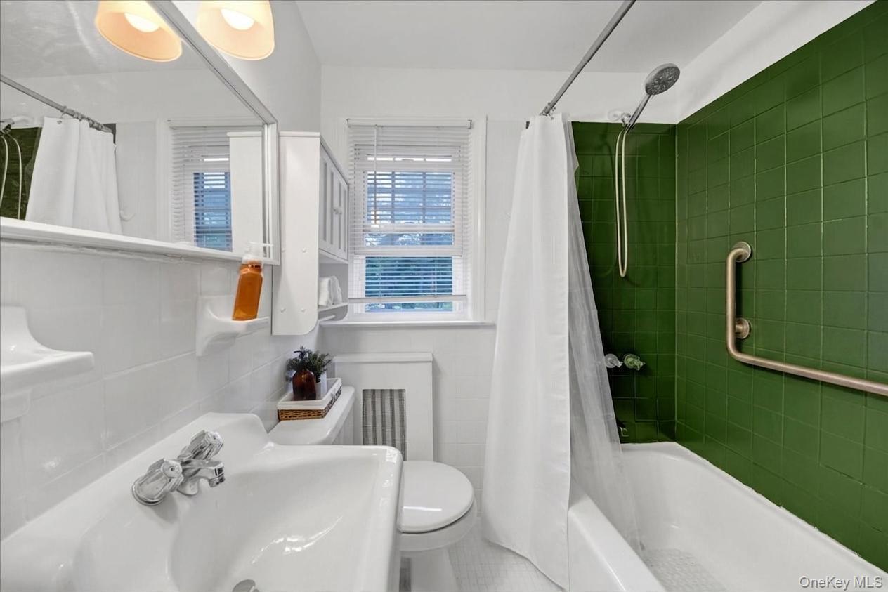 10 Susquehanna Road Ossining, NY 10562 - Photo 15 of 31 2nd floor athroom featuring green subway tile shower surround, white ceramic wall tile, built-in medicine cabinet, and a window with blinds