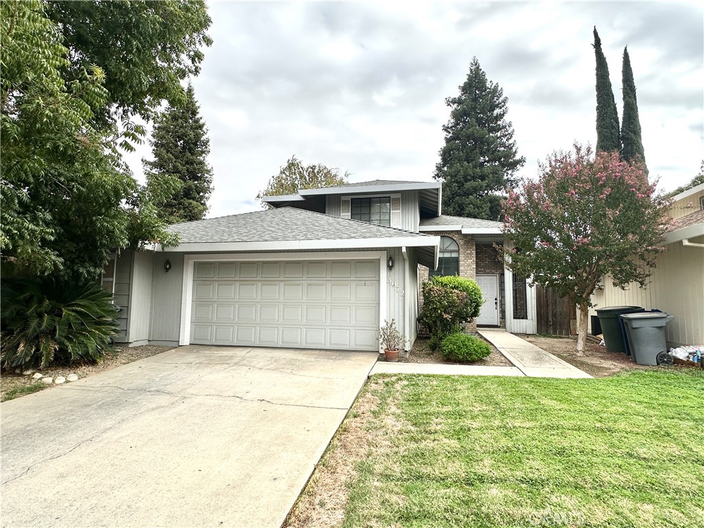 a front view of a house with a garden and trees