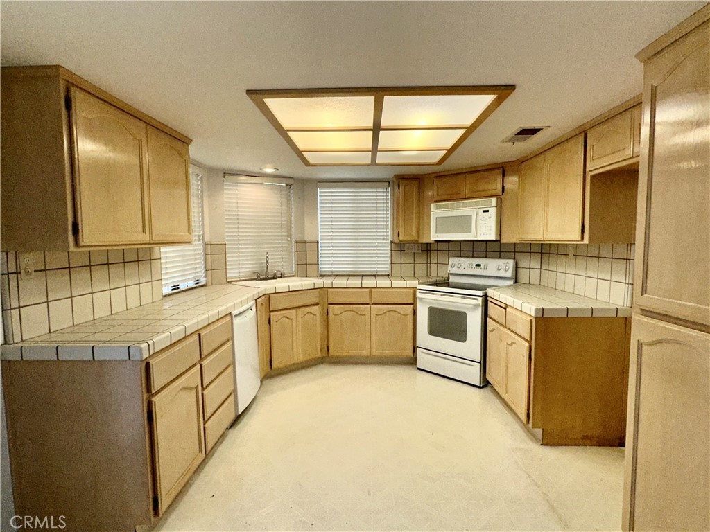 3072 Ironwood Court Merced, CA 95340 - Photo 7 of 25 a kitchen with white cabinets and white appliances