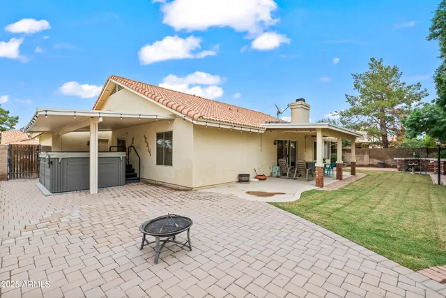 a view of a house with backyard and sitting area