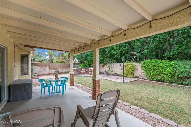 a view of a patio with a table chairs and backyard