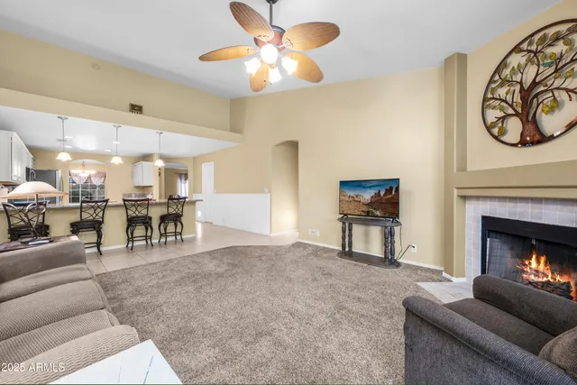 a living room with furniture a fireplace and a large window
