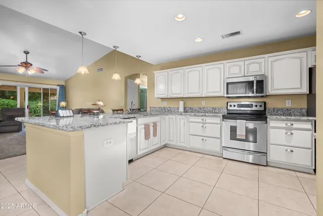 a kitchen with granite countertop a stove sink and cabinets