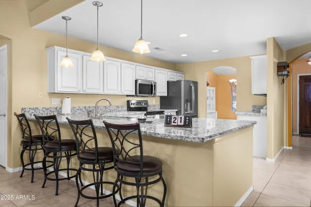 a kitchen with kitchen island granite countertop a table and chairs in it