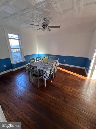 a view of a room with wooden floor table and chairs