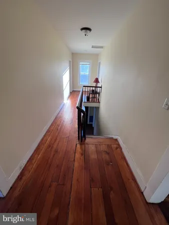 a view of empty room with wooden floor