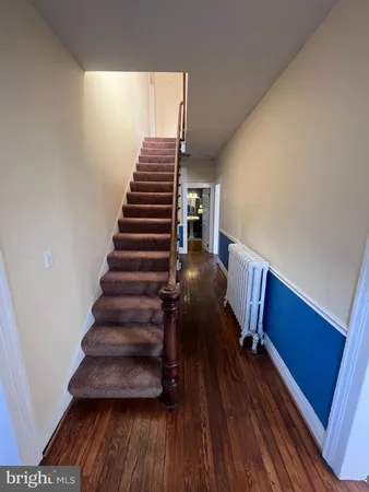 a view of entryway and hall with wooden floor