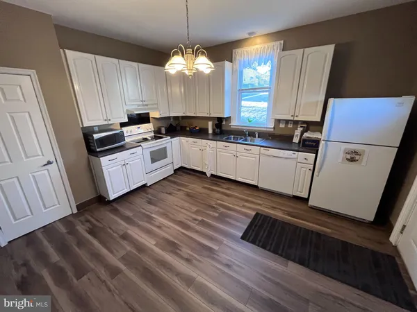 a kitchen with granite countertop white cabinets a sink and dishwasher