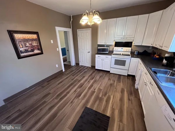 a kitchen with wooden floors and white appliances