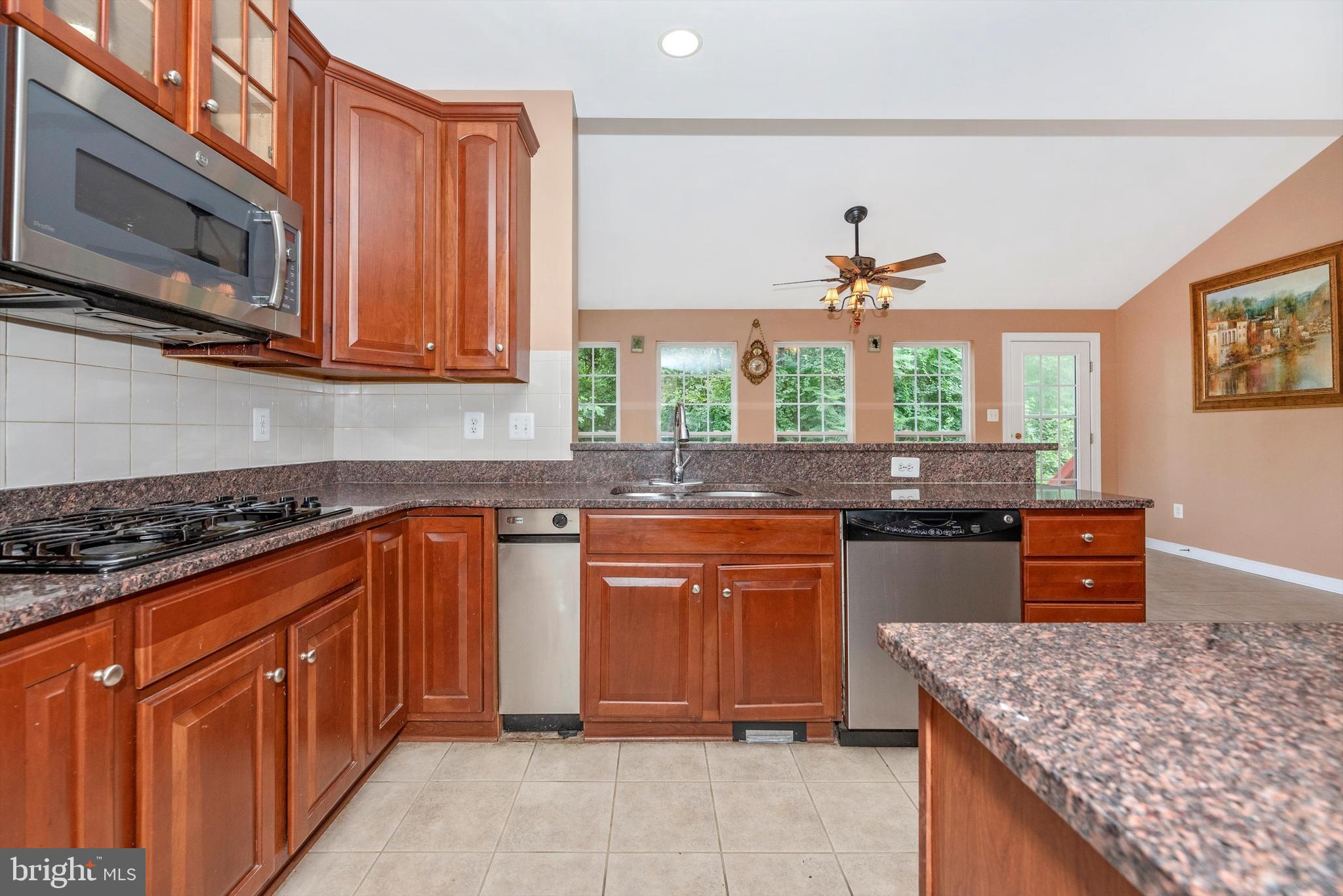 6636 South Clifton Road Frederick, MD 21703 - Photo 21 of 81 a kitchen with stainless steel appliances granite countertop a stove a sink and a microwave
