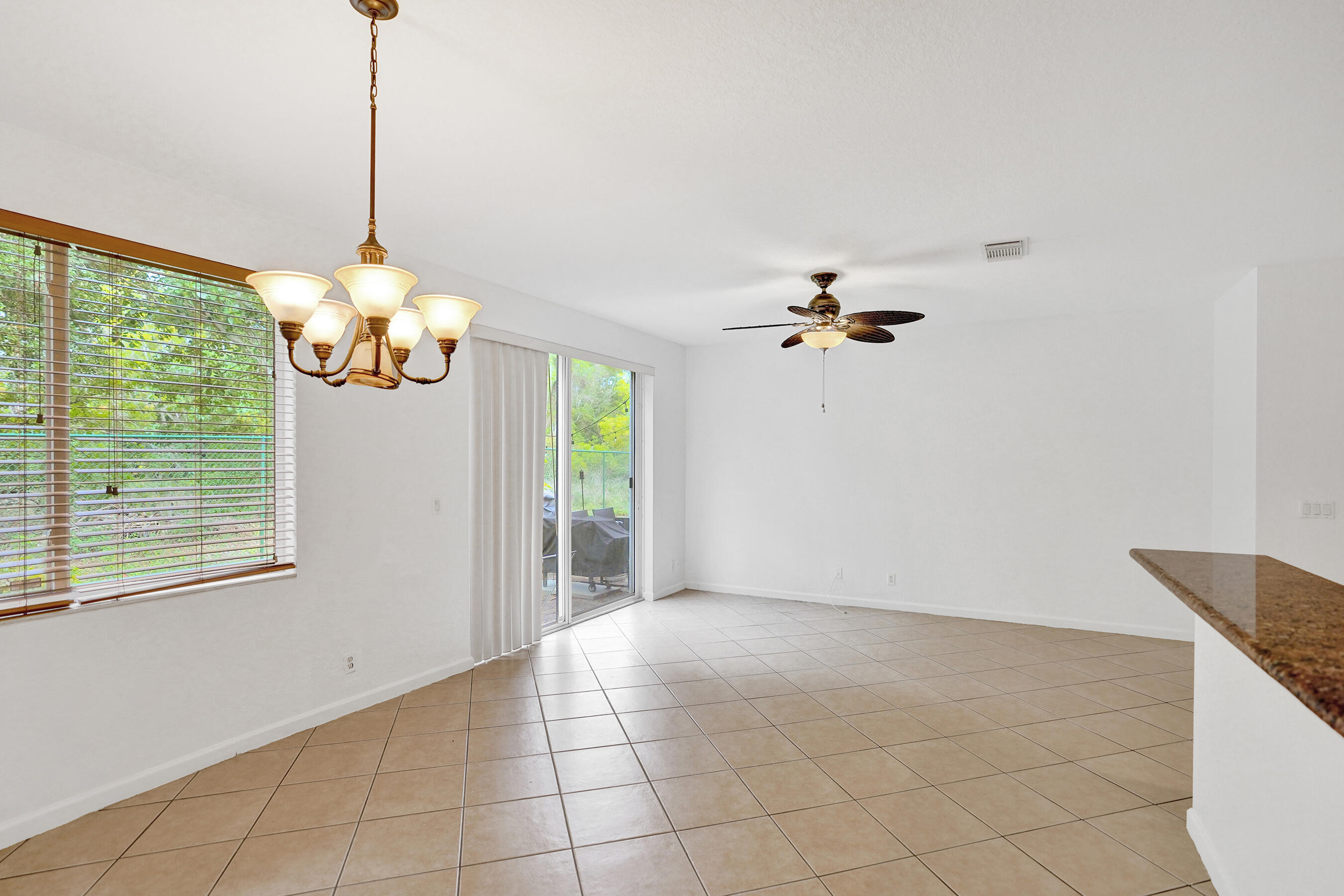 3072 North Evergreen Circle Boynton Beach, FL 33426 - Photo 17 of 55 a view of a room with a chandelier fan and windows