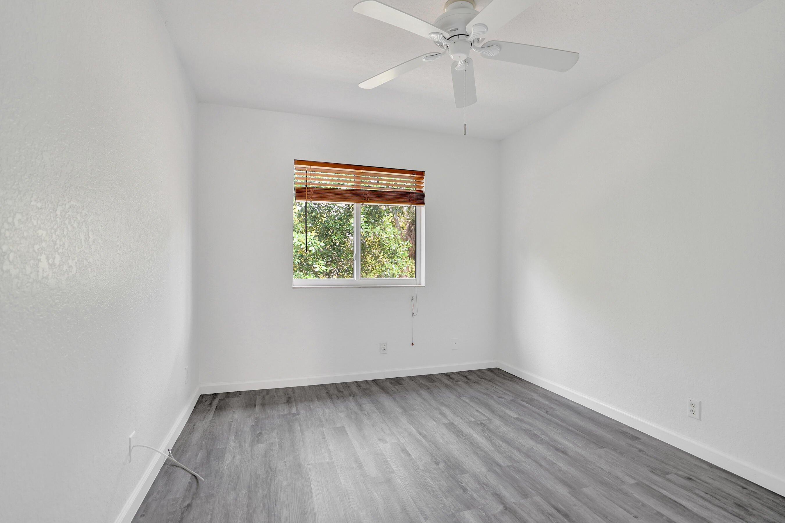 3072 North Evergreen Circle Boynton Beach, FL 33426 - Photo 32 of 55 an empty room with a window and wooden floor