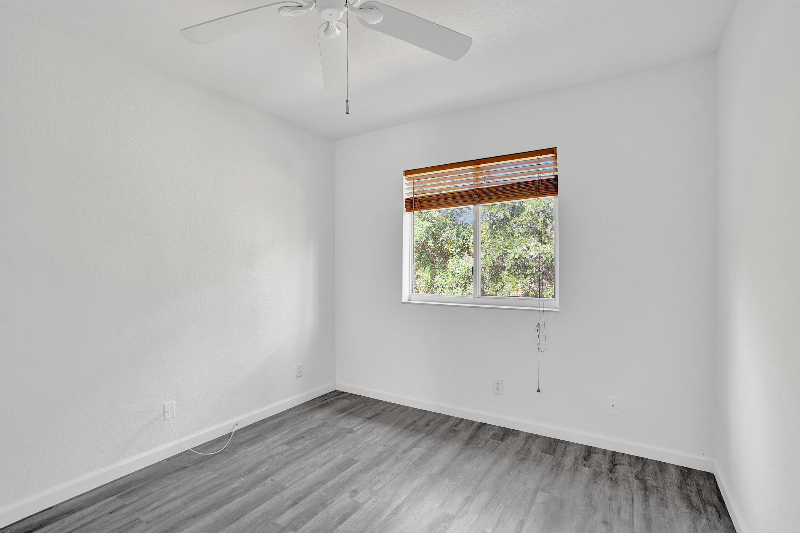 3072 North Evergreen Circle Boynton Beach, FL 33426 - Photo 33 of 55 an empty room with wooden floor fan and windows