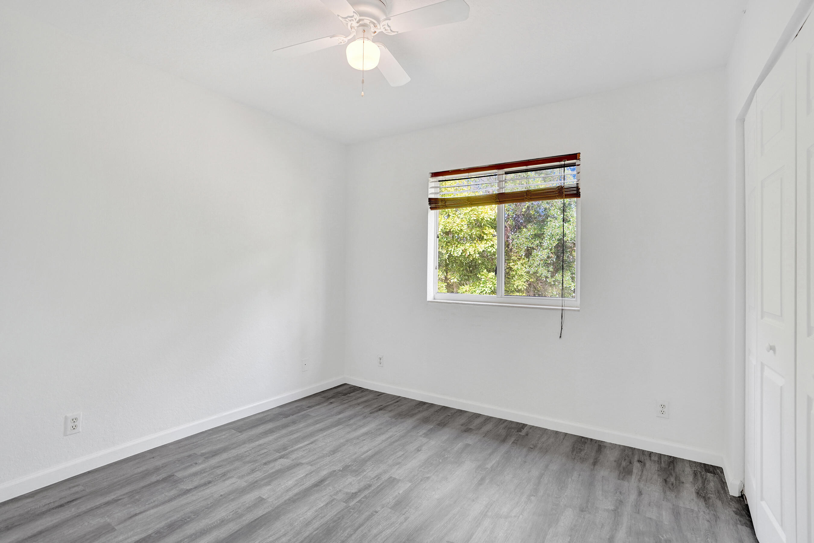 3072 North Evergreen Circle Boynton Beach, FL 33426 - Photo 36 of 55 an empty room with wooden floor and windows