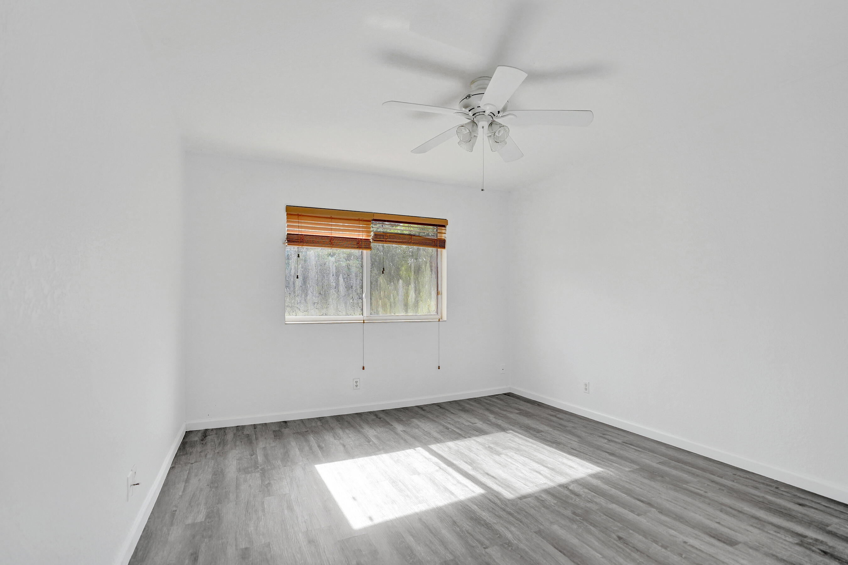3072 North Evergreen Circle Boynton Beach, FL 33426 - Photo 45 of 55 an empty room with wooden floor closet and fan