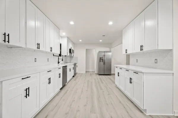 a kitchen with white cabinets and white appliances