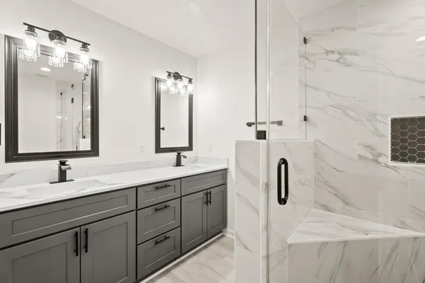 a bathroom with a double vanity sink a mirror and shower