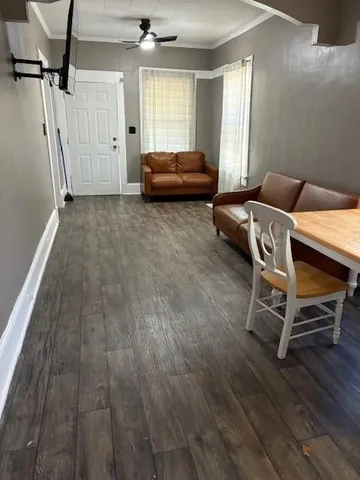 a living room with furniture and a wooden floor