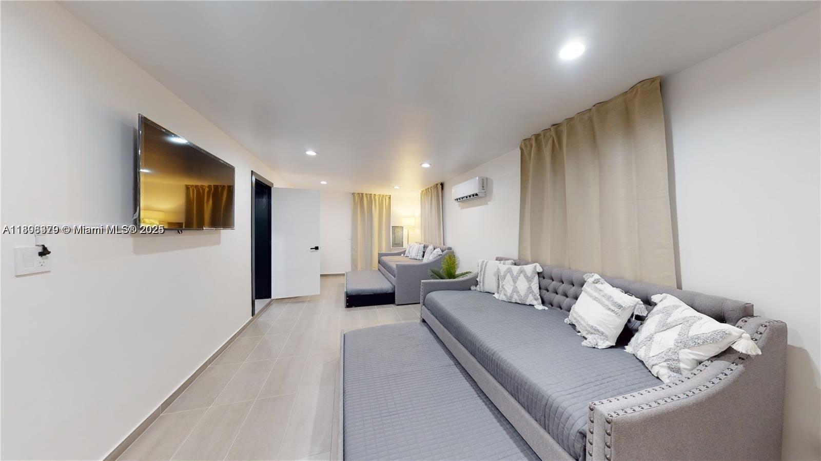 7335 Southwest 104th Street Pinecrest, FL 33156 - Photo 18 of 36 a living room with furniture and a flat screen tv