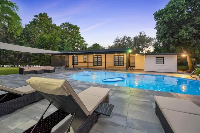 a view of a patio with swimming pool and sitting area