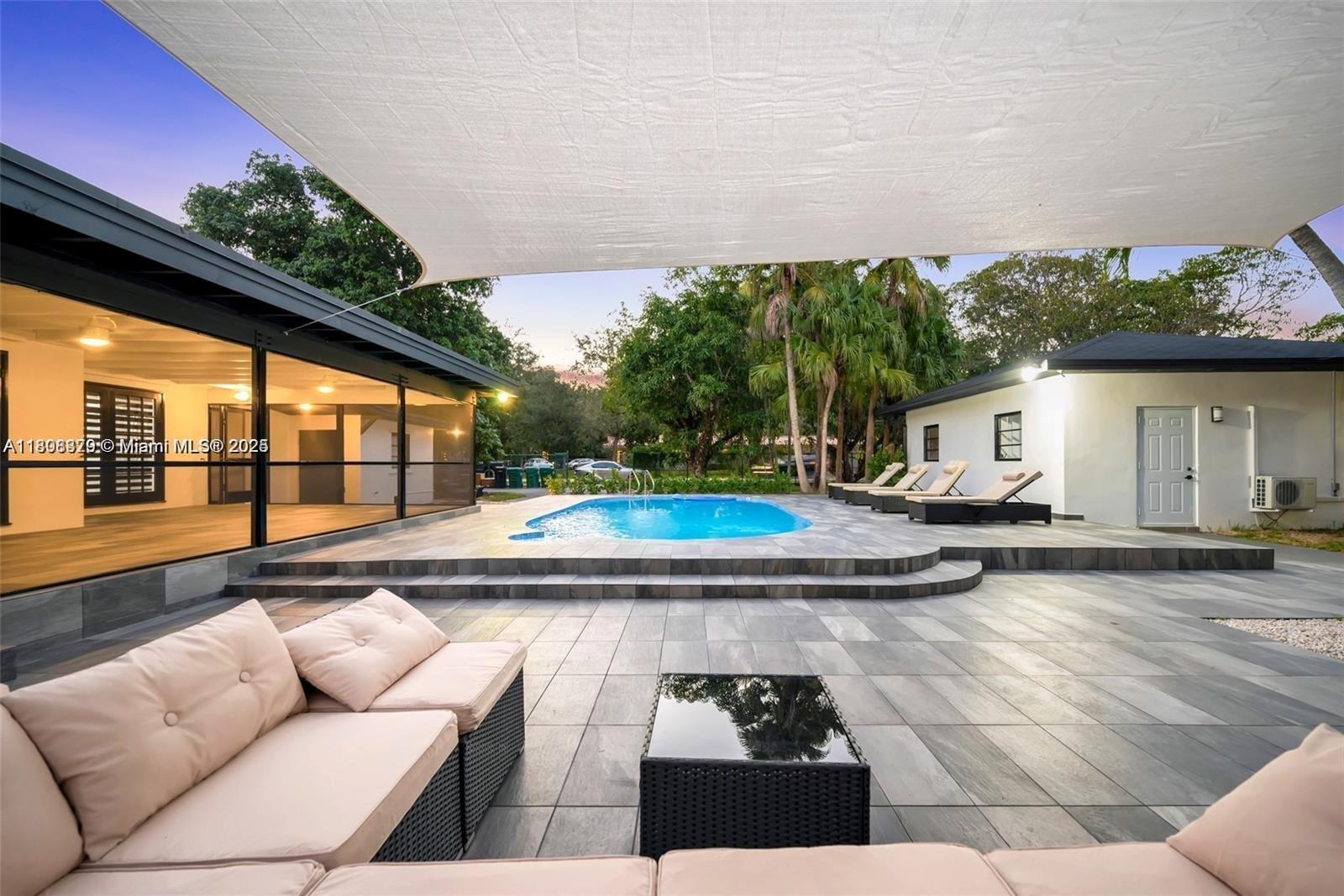 7335 Southwest 104th Street Pinecrest, FL 33156 - Photo 21 of 36 a view of a house with swimming pool and sitting area