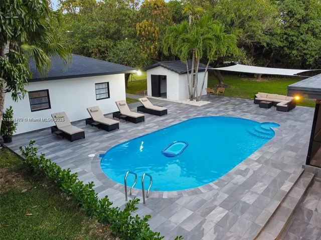 a view of a house with pool and chairs