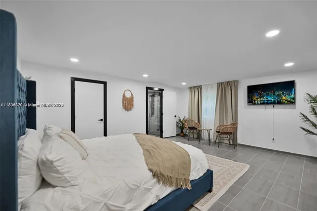 a spacious bedroom with a large bed and a flat screen tv