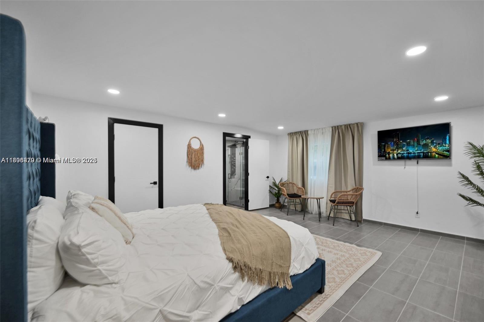 7335 Southwest 104th Street Pinecrest, FL 33156 - Photo 27 of 36 a spacious bedroom with a large bed and a flat screen tv