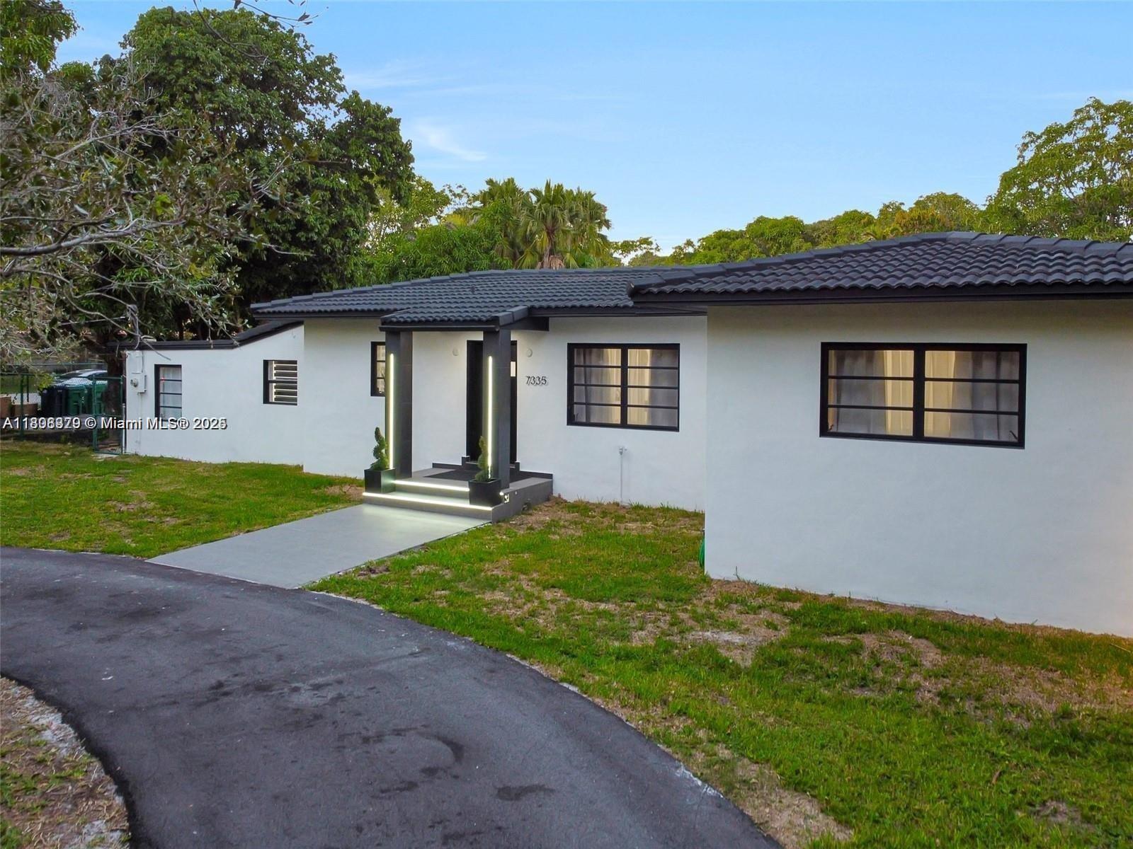 7335 Southwest 104th Street Pinecrest, FL 33156 - Photo 3 of 36 a house view with a garden space