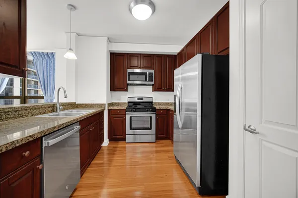 a kitchen with stainless steel appliances granite countertop a refrigerator and a stove