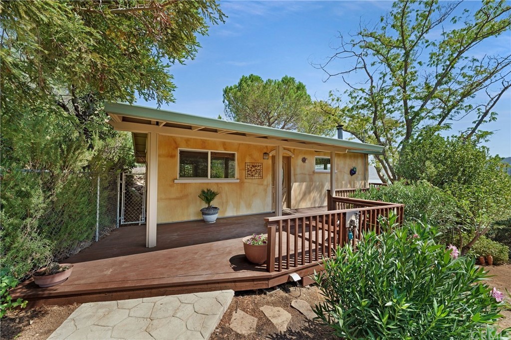 front of home with low maintenance landscaping and fountain. Deck newly refurbished and stained.