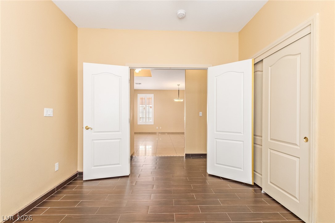 1477 Rancho Ridge Drive Henderson, NV 89012 - Photo 36 of 46 Step through French doors into this versatile living space, featuring rich wood-look tile flooring.