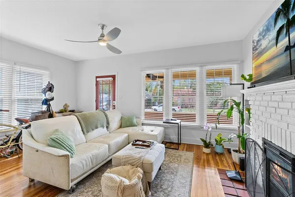 a living room with furniture a flat screen tv and a large window