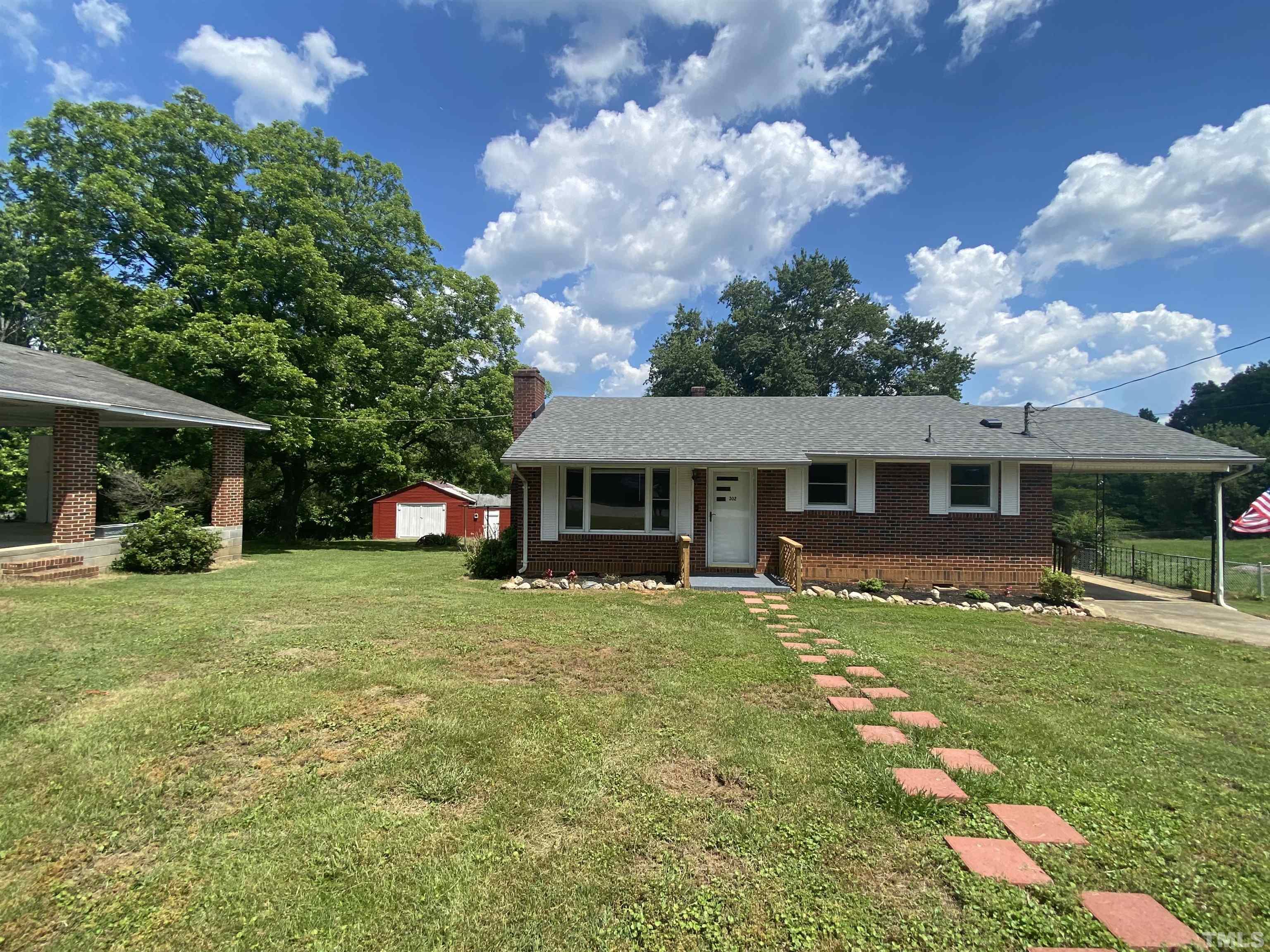 302 Allgood Street Roxboro, NC 27573 - Photo 1 of 30 front view of a house with a garden