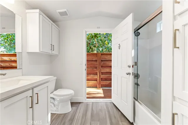 a bathroom with a sink a toilet a window and shower