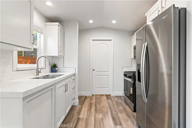a kitchen with stainless steel appliances a refrigerator sink and stove