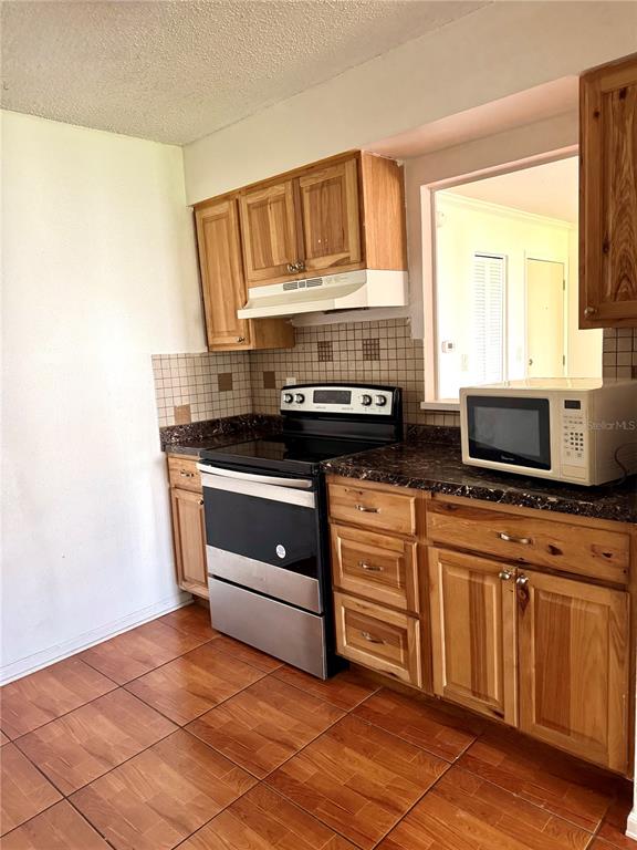 13300 Walsingham Road, Unit 161 Largo, FL 33774 - Photo 6 of 21 a kitchen with stainless steel appliances a stove and a microwave