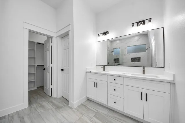 a bathroom with a double vanity sink and mirror