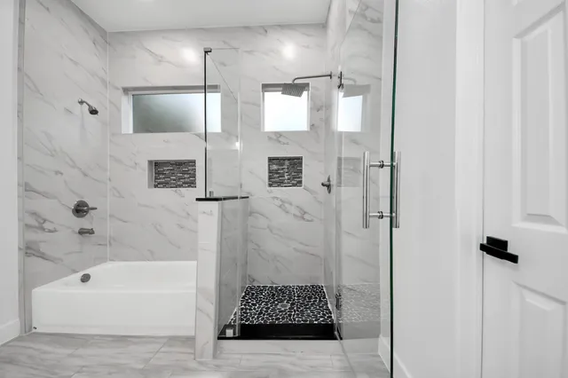 an empty room with a window and a chandelier fan