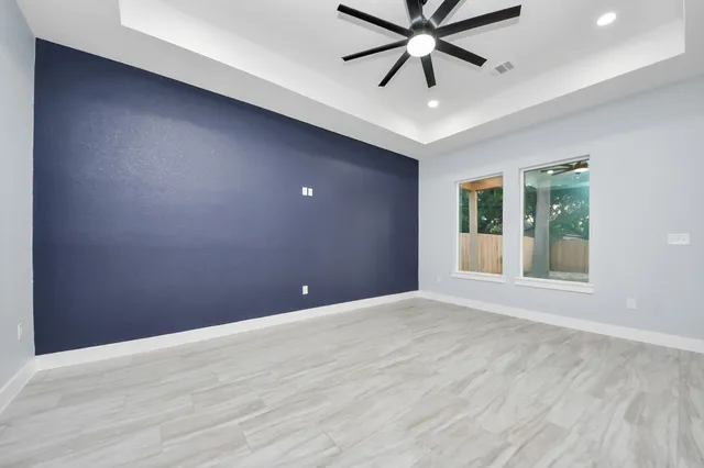 a view of an empty room with a window and a ceiling fan