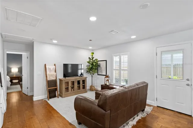 a living room with furniture wooden floor and a flat screen tv