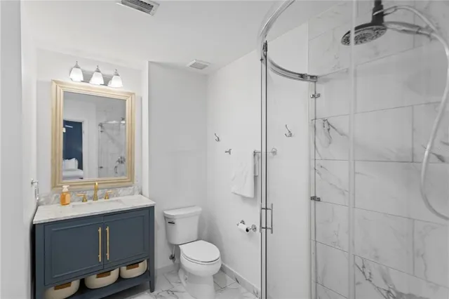 a bathroom with a sink vanity toilet and shower