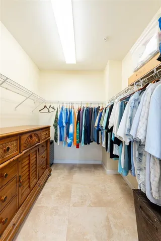 a view of walk in closet with clothes and shoes