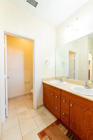 a bathroom with a double vanity sink toilet mirror and bathtub