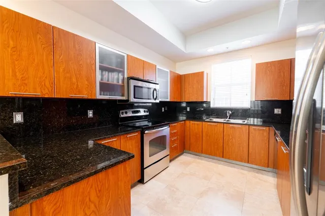 a kitchen with stainless steel appliances granite countertop a stove a sink and a microwave