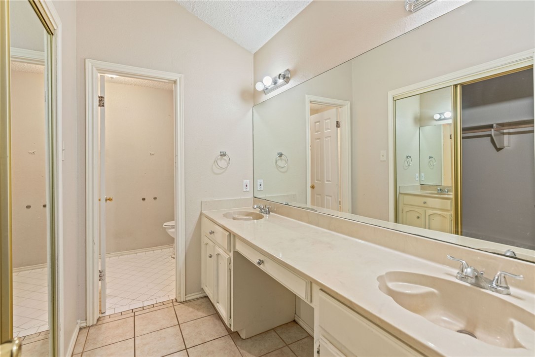 7209 Candy Ridge Road Corpus Christi, TX 78413 - Photo 13 of 24 a spacious bathroom with a granite countertop sink a mirror and a bathtub