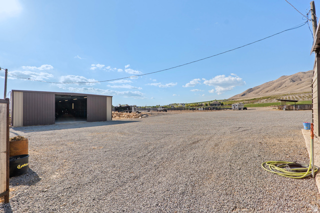 115 East 1600th Street North Santaquin, UT 84655 - Photo 29 of 52 Expansive gravel lot with a large metal outbuilding featuring wide entryways