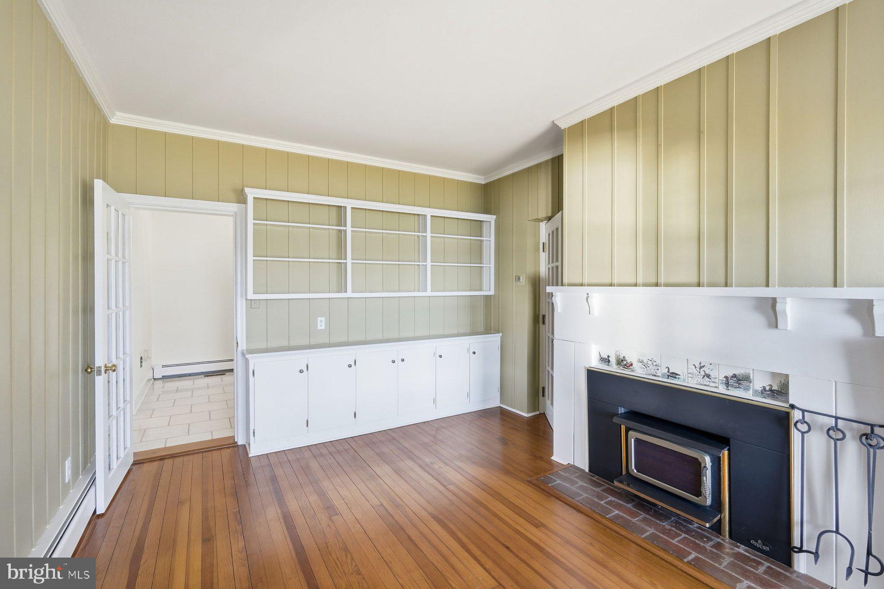 8515 Deep Cove Road Easton, MD 21601 - Photo 12 of 55 a kitchen with a wooden floor and a fireplace