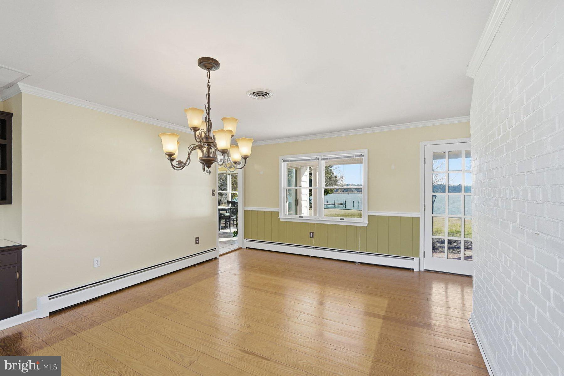 8515 Deep Cove Road Easton, MD 21601 - Photo 19 of 55 a view of a room with window wooden floor and a chandelier