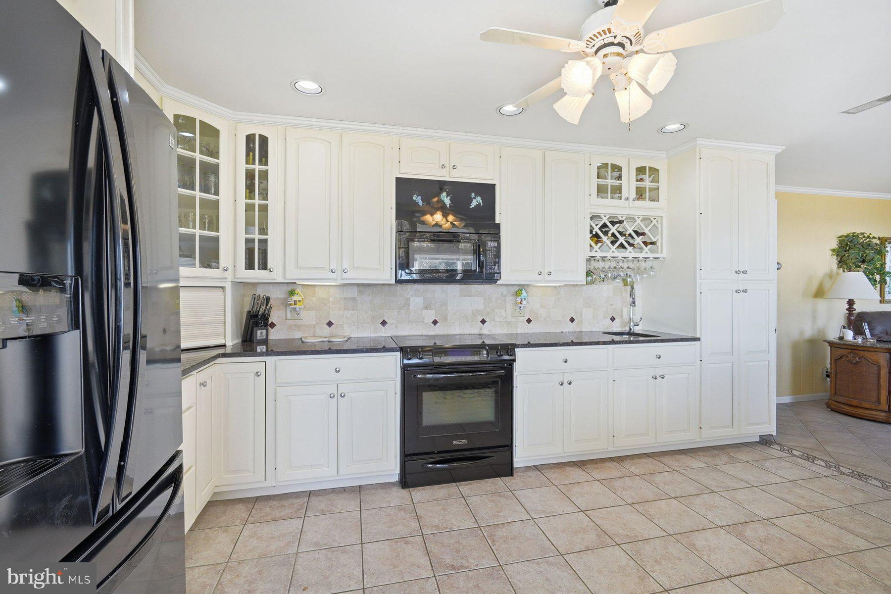 8515 Deep Cove Road Easton, MD 21601 - Photo 20 of 55 a kitchen with granite countertop white cabinets stainless steel appliances a sink and a window